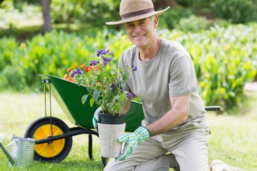 Trained gardener using tools carefully during garden maintenance in New Eltham